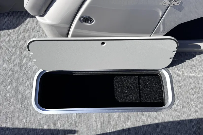 Slide: The Image of Open storage compartment on 2026 Sylvan L3 CLZ boat, featuring sleek design and carpeted interior. - 21