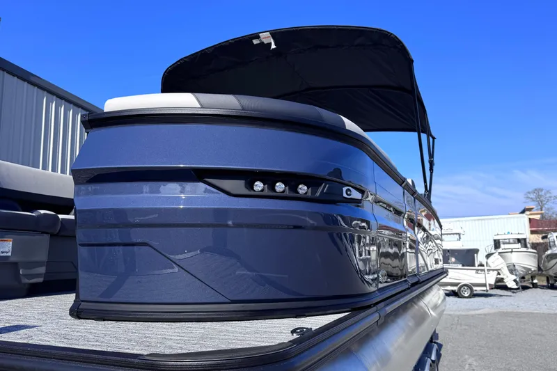 Slide: The Image of 2026 Sylvan L3 CLZ pontoon boat with sleek blue design and canopy under clear sky. - 5