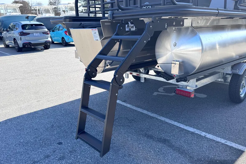 Slide: The Image of 2026 Sylvan L3 CLZ pontoon boat ladder and trailer in parking lot. - 7