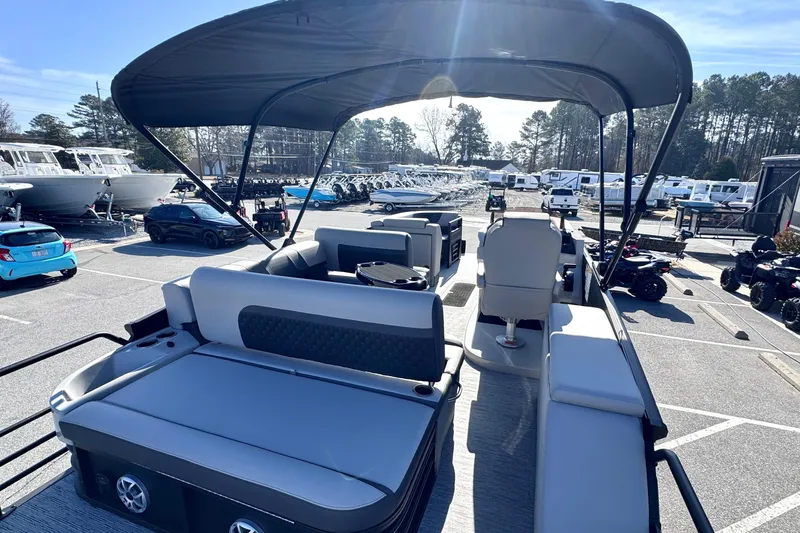 Slide: The Image of 2026 Sylvan L3 CLZ pontoon boat with canopy in a parking lot, surrounded by vehicles. - 8