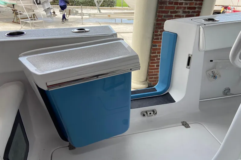 Slide: The Image of Interior of 2026 Sportsman Heritage 261 Center Console boat with blue storage compartment. - 38