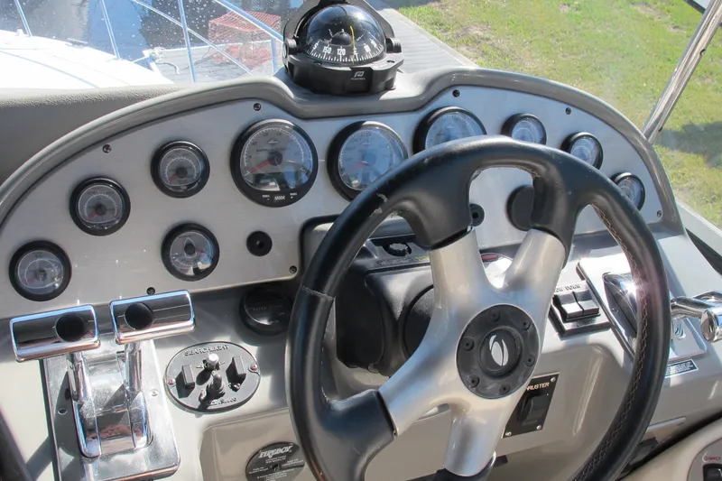 Slide: The Image of Steering wheel and dashboard of 2006 Cruisers Yachts 385 Motoryacht, featuring gauges and controls. - 13