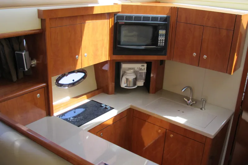 Slide: The Image of Luxurious 2006 Cruisers Yachts 385 Motoryacht kitchen with wood cabinetry and modern appliances. - 24