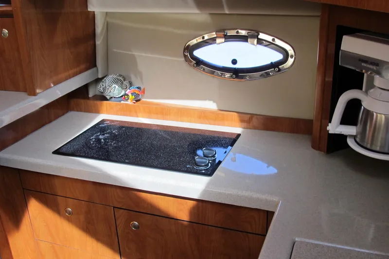 Slide: The Image of 2006 Cruisers Yachts 385 Motoryacht kitchen with stove, porthole, and coffee maker. - 30