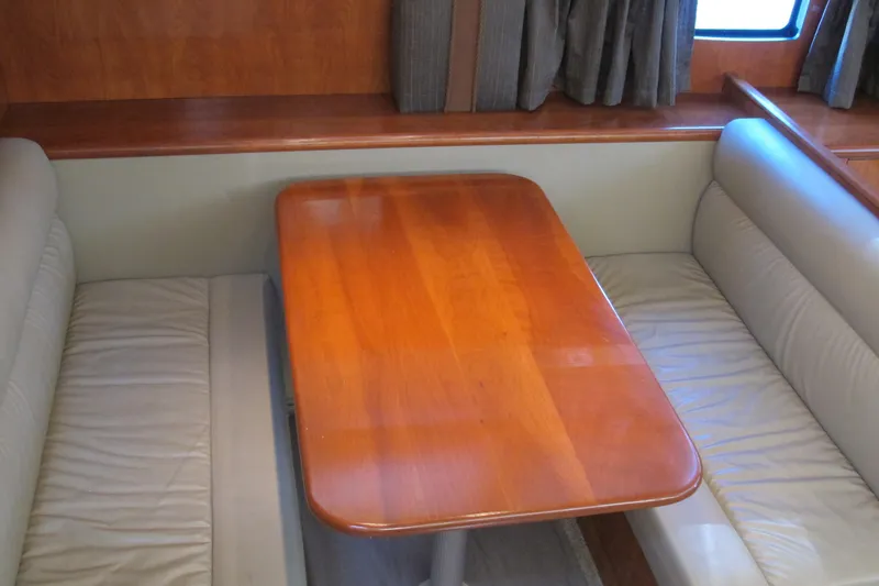 Slide: The Image of Interior dining area of 2006 Cruisers Yachts 385 Motoryacht with wooden table and leather seating. - 34