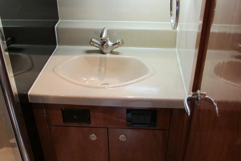 Slide: The Image of 2006 Cruisers Yachts 385 Motoryacht bathroom sink with modern faucet and wooden cabinetry. - 44