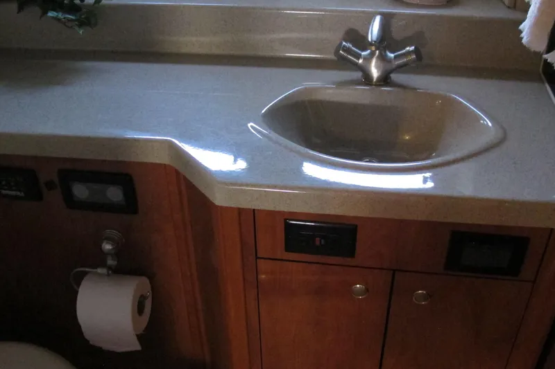 Slide: The Image of 2006 Cruisers Yachts 385 Motoryacht bathroom sink with wooden cabinetry and fixtures. - 54
