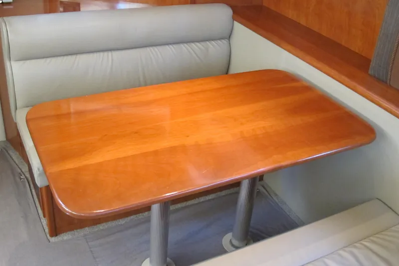 Slide: The Image of 2006 Cruisers Yachts 385 Motoryacht interior with wooden dining table and cushioned seating. - 32