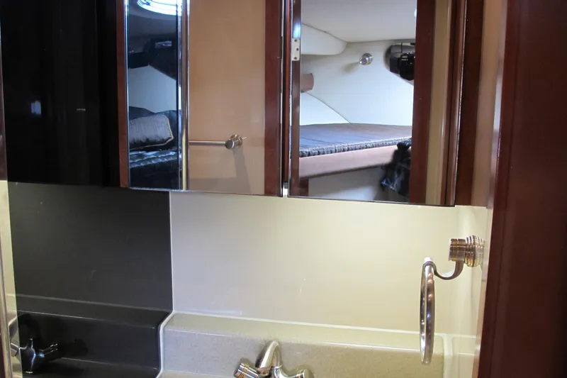 Slide: The Image of 2006 Cruisers Yachts 385 Motoryacht bathroom with sink and mirror reflecting cabin interior. - 45