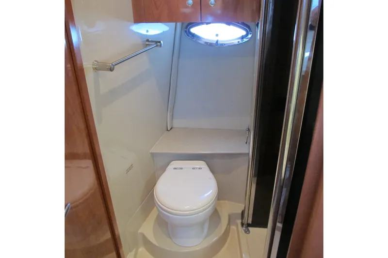 Slide: The Image of 2006 Cruisers Yachts 385 Motoryacht bathroom with toilet and porthole window. - 46