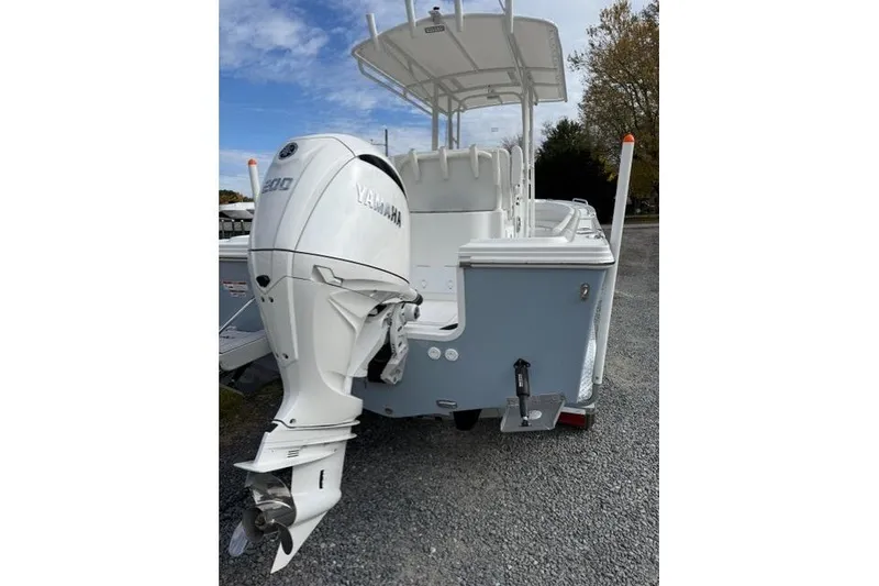 Slide: The Image of 2022 Parker 1801 Center Console boat with steering wheel and seating, under a blue sky. - 2