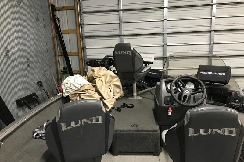 Slide: The Image of 2015 Lund 1675 Impact boat interior with seats, steering wheel, and Humminbird equipment. - 7