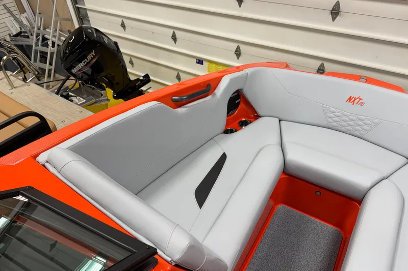 Slide: The Image of 2026 MasterCraft NXT22 boat interior with gray seating and orange accents. - 10