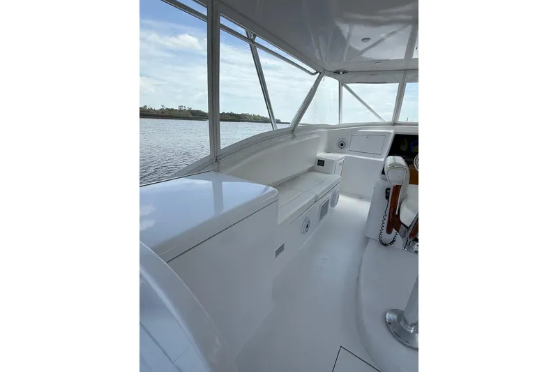 Slide: The Image of 2006 Custom Carolina Heritage Express boat interior with white seating and helm, overlooking water. - 13