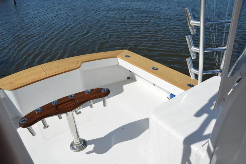 Slide: The Image of 2006 Custom Carolina Heritage Express boat deck with rod holders, overlooking calm water. - 17