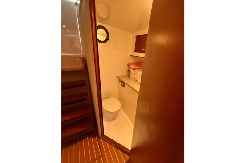 Slide: The Image of 2006 Custom Carolina Heritage Express boat bathroom with wooden accents and compact design. - 30
