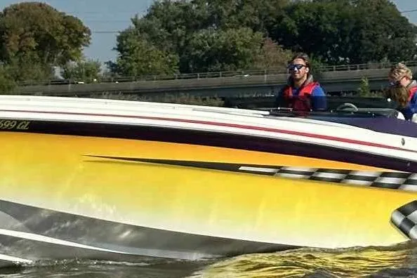 The Image of 2000 Hustler 388 SLINGSHOT speedboat on water, featuring vibrant yellow and white design. - 1