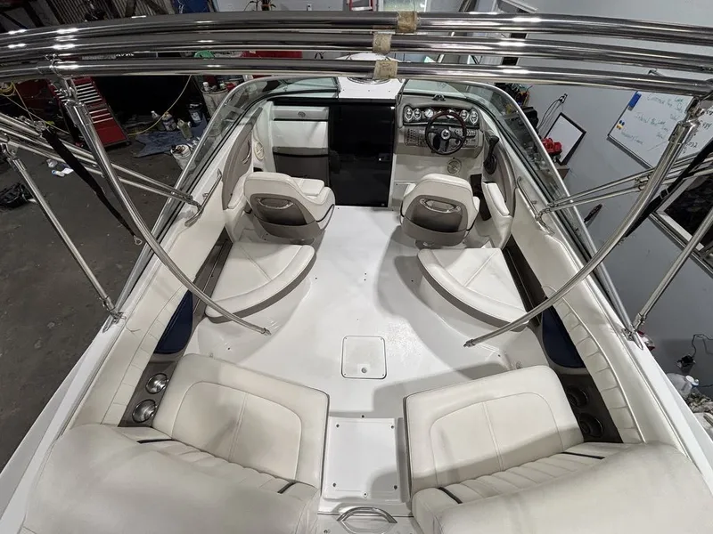 Slide: The Image of 2005 Cobalt 255 Express boat interior with white seating and steering console. - 4