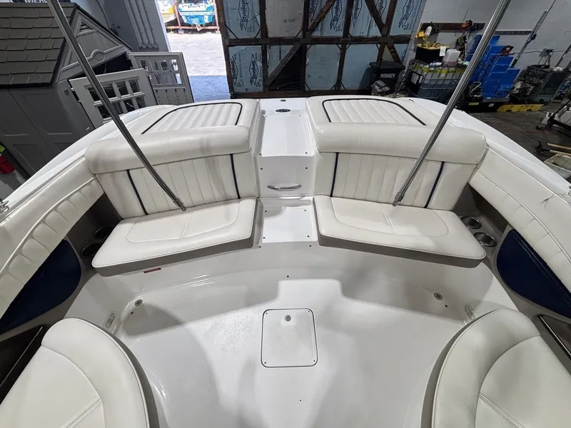 Slide: The Image of 2005 Cobalt 255 Express boat interior with white seating and storage compartments. - 5