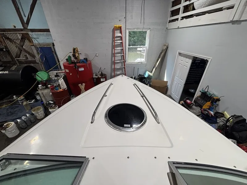 Slide: The Image of 2005 Cobalt 255 Express boat in a workshop, showing bow and hatch. - 9