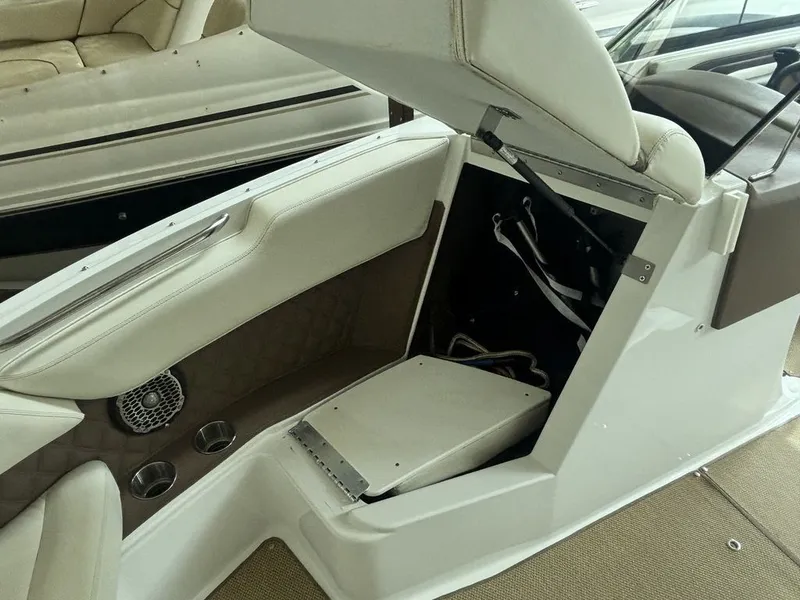 Slide: The Image of 2014 Cobalt A25 boat interior with open storage compartment and cup holders. - 17