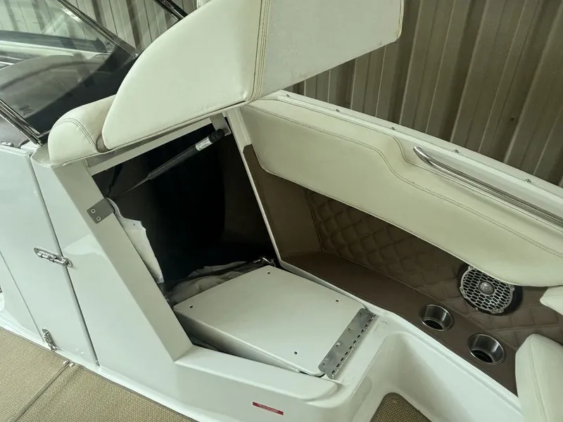 Slide: The Image of 2014 Cobalt A25 boat interior with white seating and storage compartment. - 18