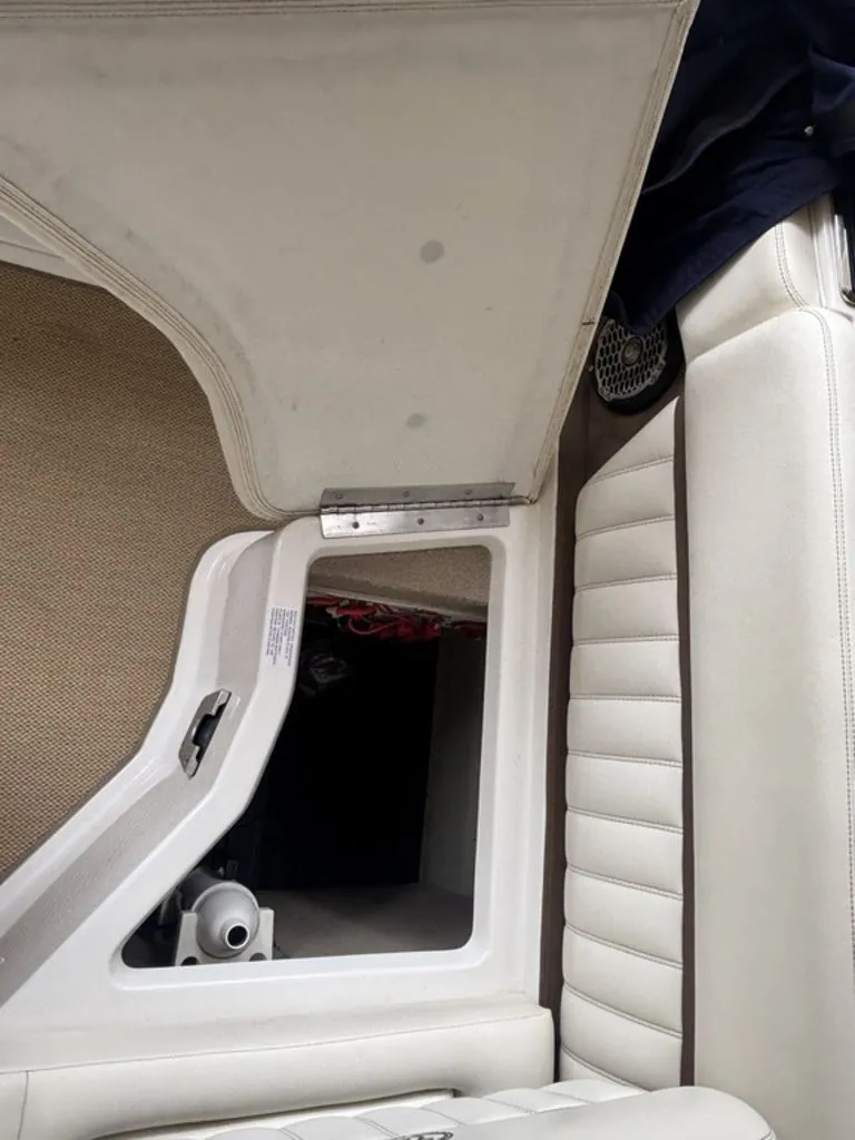 Slide: The Image of 2014 Cobalt A25 boat interior with open storage compartment and white seating. - 20