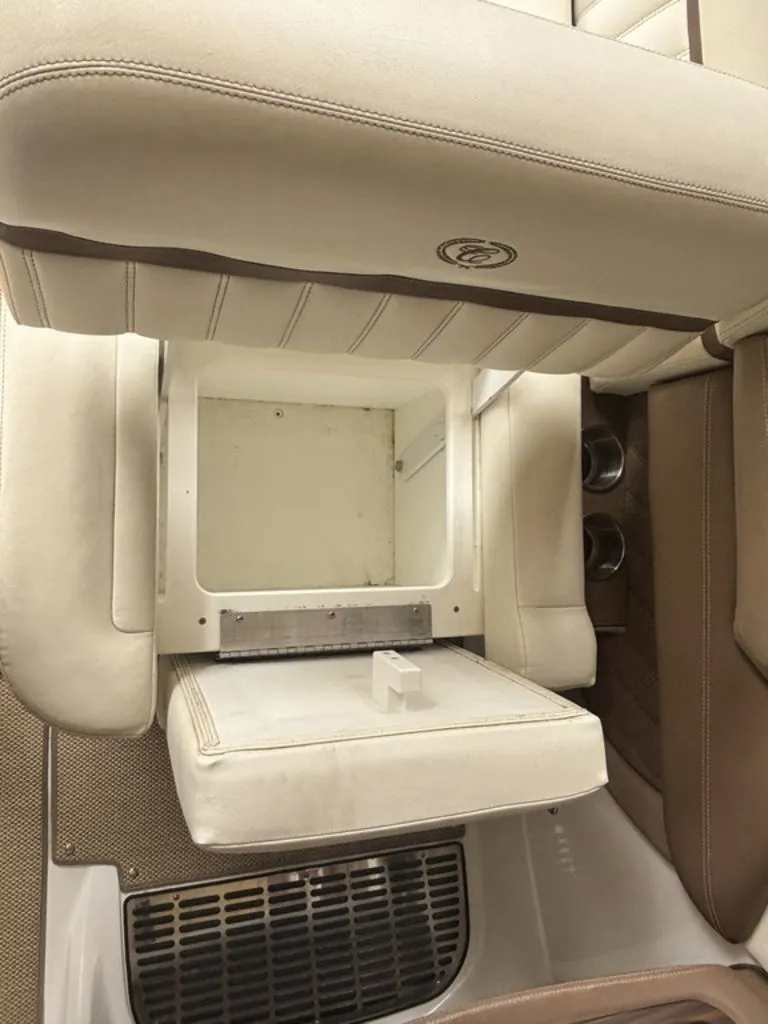 Slide: The Image of 2014 Cobalt A25 boat interior with open storage compartment and cup holders. - 21