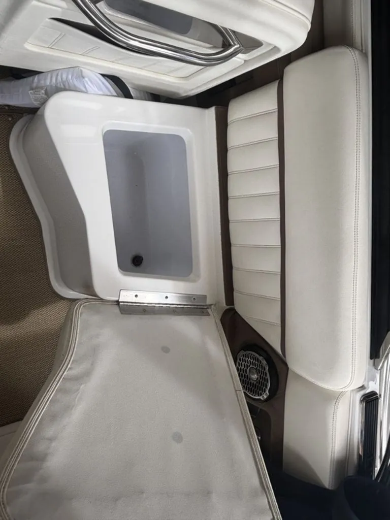 Slide: The Image of 2014 Cobalt A25 boat interior with open storage compartment and cushioned seating. - 22