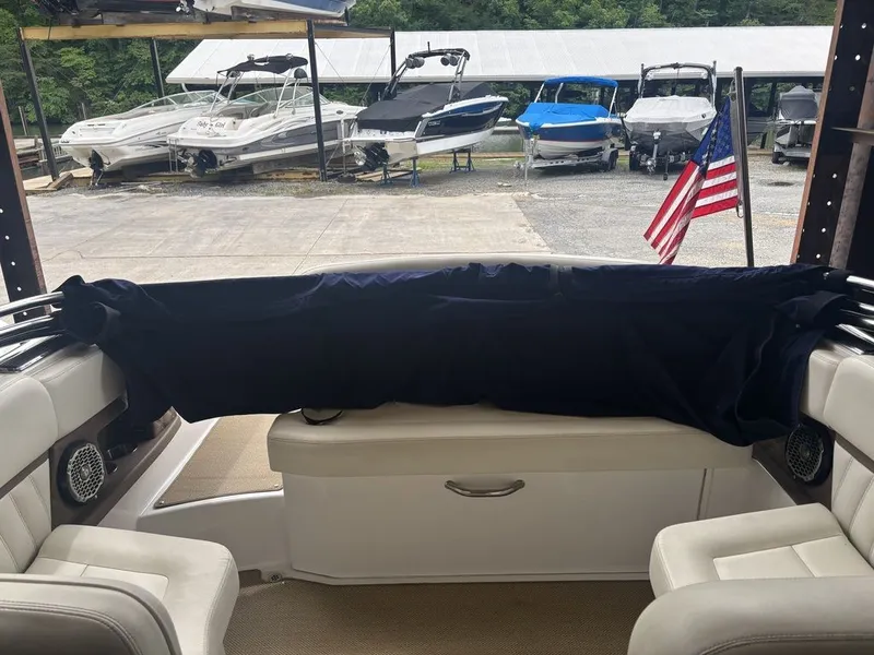 Slide: The Image of Interior of a 2014 Cobalt A25 boat with American flag and docked boats. - 7