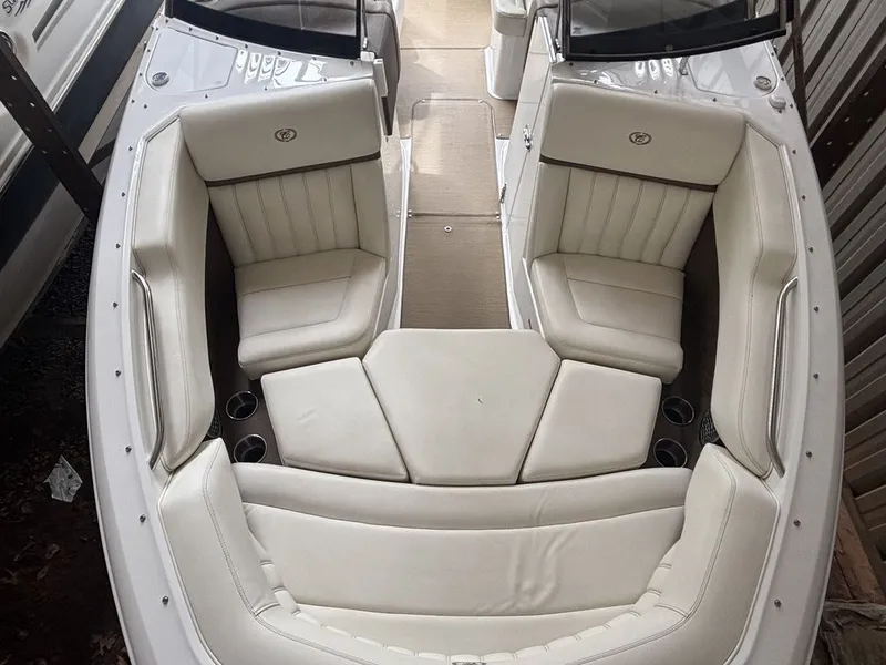 Slide: The Image of 2014 Cobalt A25 boat interior with white leather seating and cup holders. - 9