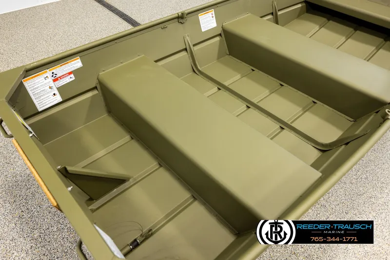 Slide: The Image of 2026 Lund 1040 boat interior with green finish, featuring bench seats and safety labels. - 10