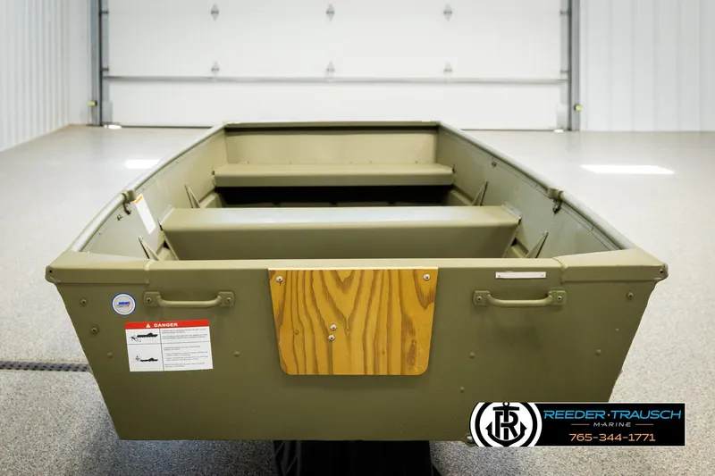 Slide: The Image of 2026 Lund 1040 boat in a showroom, featuring a green exterior and wooden accents. - 5