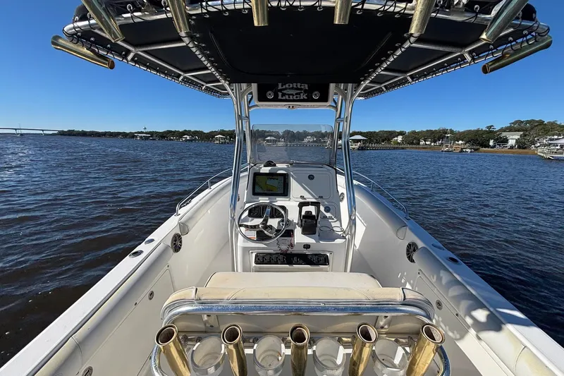 Slide: The Image of 2006 Century 2600 Center Console boat on water, featuring helm and fishing rod holders. - 13