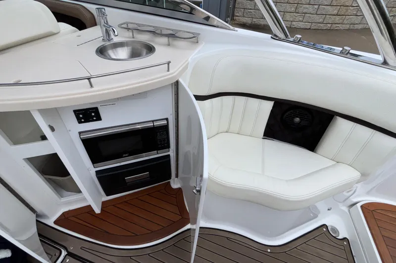 Slide: The Image of 2022 Cobalt R35 boat interior with kitchenette, sink, and seating area. - 29