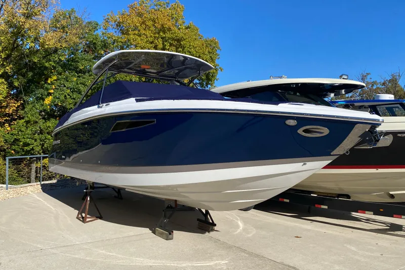 Slide: The Image of 2022 Cobalt R35 boat on display, blue and white design, sunny day, surrounded by trees. - 3