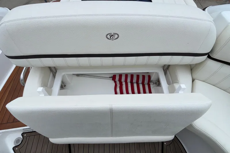 Slide: The Image of 2022 Cobalt R35 boat seat with storage compartment, featuring white upholstery and striped fabric. - 30
