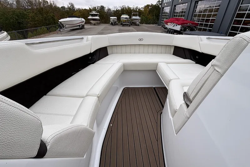 Slide: The Image of 2022 Cobalt R35 boat interior with white seating and wooden flooring, docked near other boats. - 40