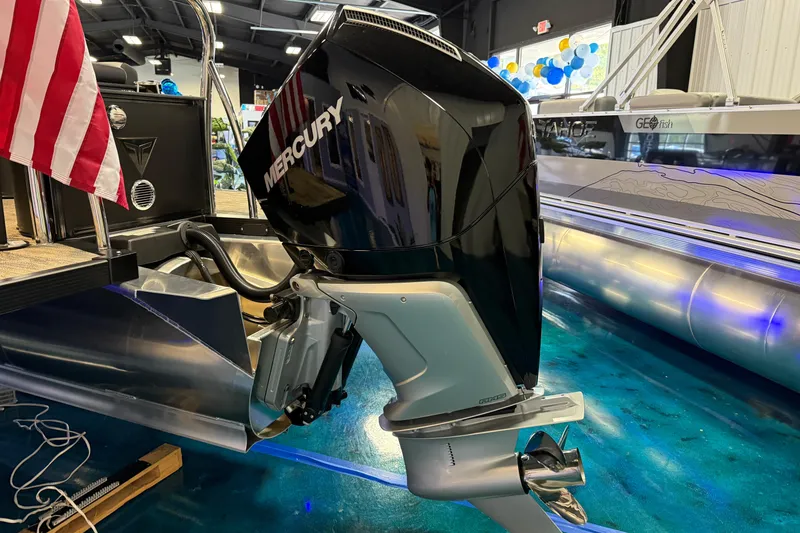 Slide: The Image of 2026 Tahoe Pontoon Cascade Cruise with Mercury engine, displayed indoors with American flag. - 4