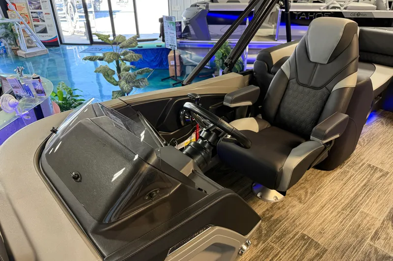 Slide: The Image of 2026 Tahoe Pontoon Cascade Cruise Rear Bench interior with captain's chair and steering console. - 7
