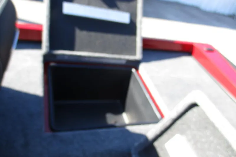 Slide: The Image of Open storage compartment on 2026 Ranger RT188P Fishing boat, featuring red and black interior. - 22