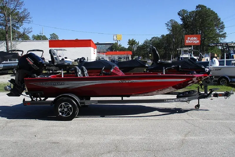 Slide: The Image of 2026 Ranger RT188P Fishing boat in red, parked on a trailer in a lot. - 6