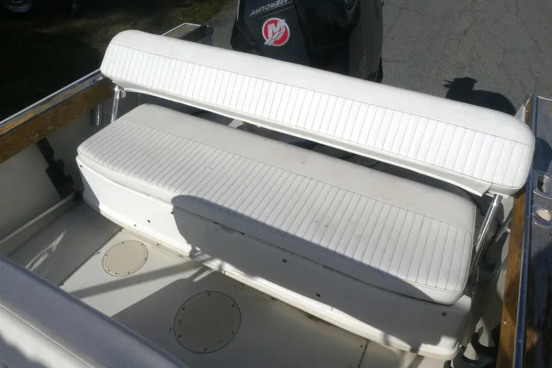 Slide: The Image of 1989 Boston Whaler 220 Outrage boat interior with white cushioned seating. - 10