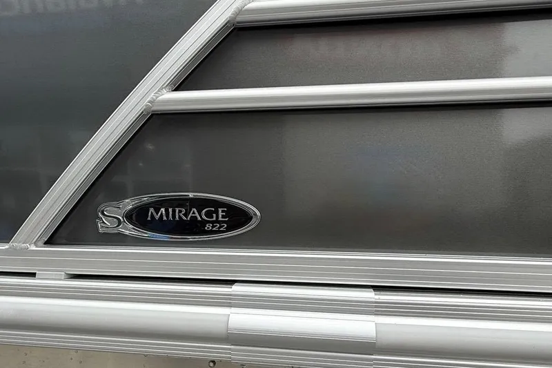 Slide: The Image of 2026 Sylvan Mirage 822 PARTY FISH boat emblem on metallic surface. - 5