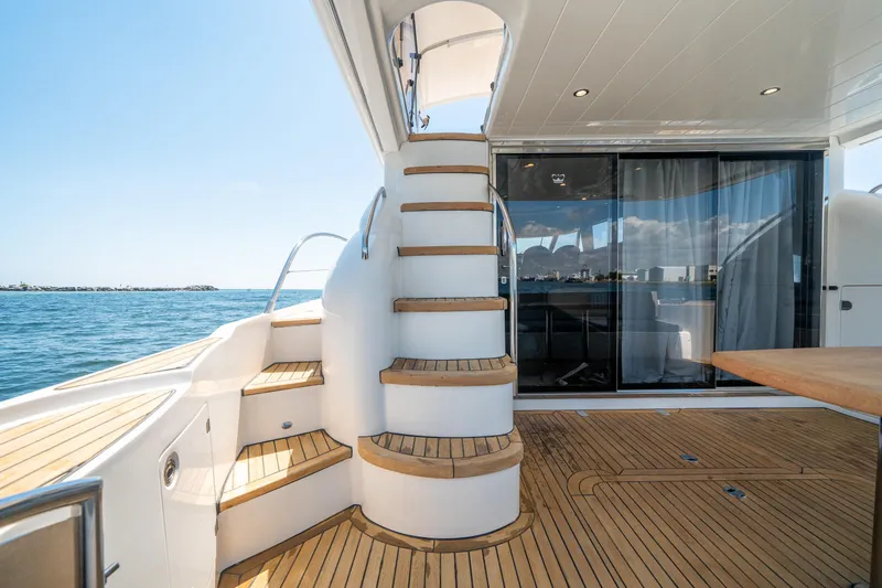 Slide: The Image of 2008 Princess 58 Flybridge yacht with elegant wooden deck and spiral staircase. - 11