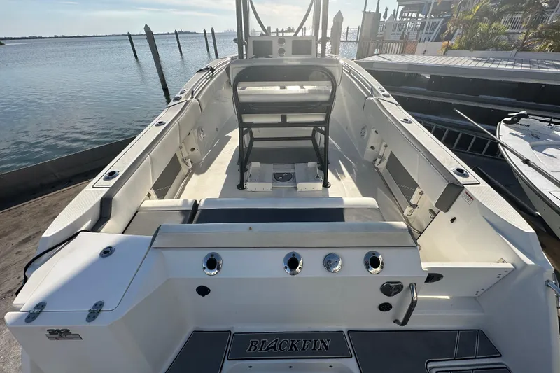 Slide: The Image of 2018 Blackfin 212 CC boat interior with seating, docked by the water. - 16
