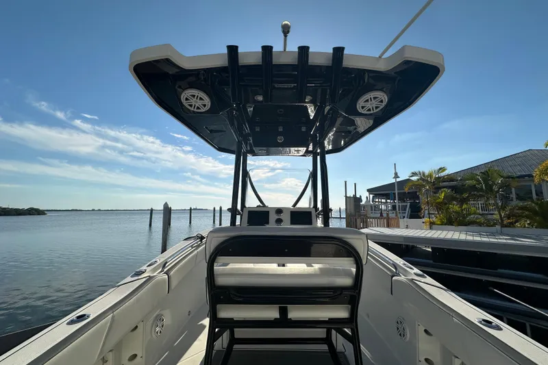 Slide: The Image of 2018 Blackfin 212 CC boat docked, featuring a spacious deck and T-top under a clear sky. - 17