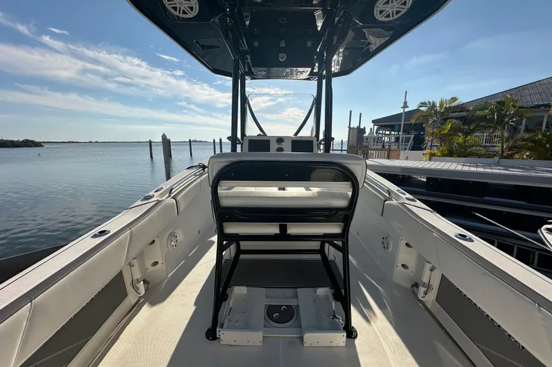 Slide: The Image of 2018 Blackfin 212 CC boat interior with seating, docked by the water. - 18