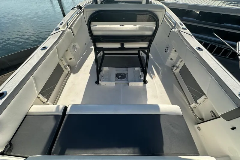 Slide: The Image of 2018 Blackfin 212 CC boat interior with seating and storage, docked by the water. - 19