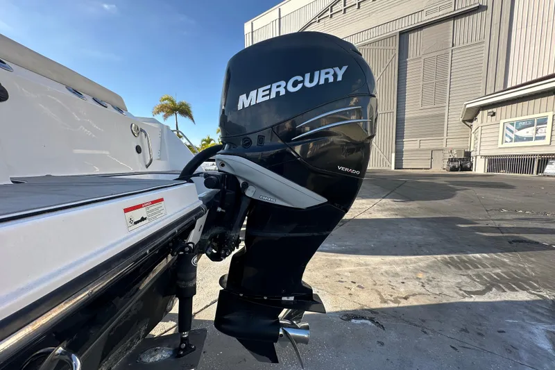 Slide: The Image of 2018 Blackfin 212 CC with Mercury Verado outboard motor at a marina. - 2